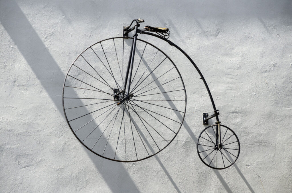 Antique penny farthing bicycle mounted on a wall, representing early bicycle history